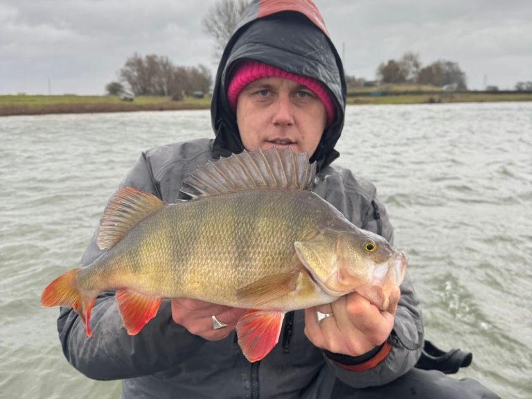 Een visser en een jongen tonen trots een grote snoek op een boot.